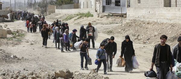 Syrians civilians evacuated from the Eastern Ghouta enclave pass with belongings through the regime-controlled corridor opened by government forces in Hawsh al-Ashaari, east of the enclave town of Hamouria on the outskirts of the capital Damascus on March 15, 2018 Syrians civilians evacuated from the Eastern Ghouta enclave pass with belongings through the regime-controlled corridor opened by government forces in Hawsh al-Ashaari, east of the enclave town of Hamouria on the outskirts of the capital Damascus on March 15, 2018 - Sputnik International