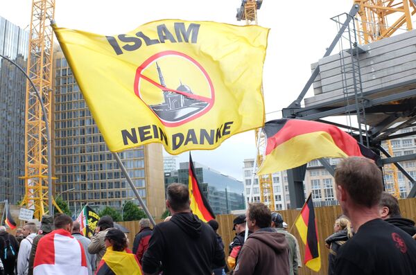 Participants in the rally to protest German Chancellor Angela Merkel's open door immigration policy in Berlin Participants in the rally to protest German Chancellor Angela Merkel's open door immigration policy in Berlin - Sputnik International