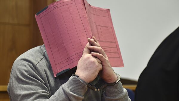 In this Feb. 26, 2015 file photo former nurse Niels Hoegel., accused of multiple murder and attempted murder of patients, covering his face with a file at the district court in Oldenburg, Germany - Sputnik International
