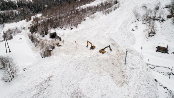 (File) Excavators remove the snow on the site of an avalanche that covered the railway of the Brig Visp Zermatt Bahn company between Visp and Taesch on January 10, 2018 near Sankt Niklaus, Swiss Alps - Sputnik International