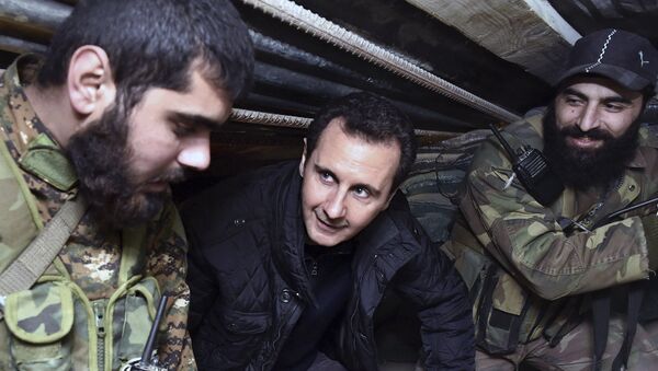 (File) This Wednesday, Dec. 31, 2014, file photo released by the Syrian official news agency SANA, Syrian President Bashar Assad, center, speaks with Syrian troops during his visit to the front line in the eastern Damascus district of Jobar, Syria - Sputnik International