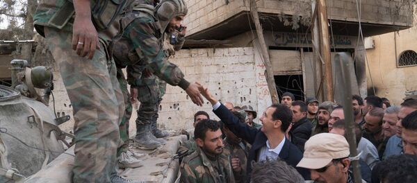 Syrian President Bashar al-Assad reaches out to shake the hand of a Syrian army soldier in eastern Ghouta, Syria, March 18, 2018 - Sputnik International
