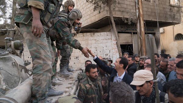 Syrian President Bashar al-Assad reaches out to shake the hand of a Syrian army soldier in eastern Ghouta, Syria, March 18, 2018 - Sputnik International
