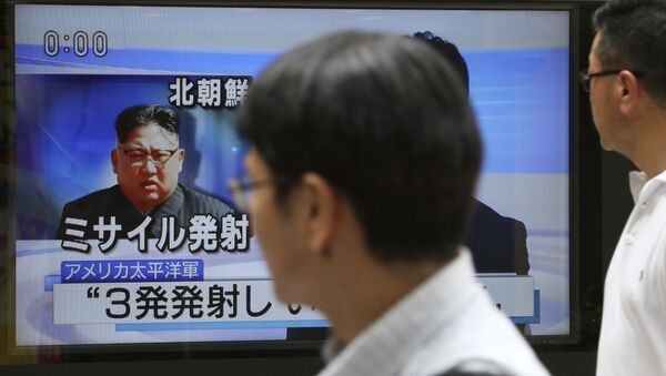 Passers-by watch a TV news program showing image of North Korean leader Kim Jong Un, in Tokyo, Saturday, Aug. 26, 2017 - Sputnik International