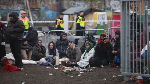 Migrants sit on the ground before leaving an illegal camp set up in Malmoe, on November 3, 2015, after the police started clearing the Roma camp after a months-long standoff between city authorities and about 200 people who had settled there without permissio - Sputnik International