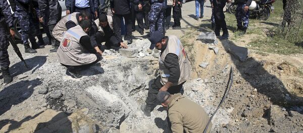 Hamas security services personnel inspect the site of a Tuesday explosion that occurred as the convoy of Palestinian Prime Minister Rami Hamdallah entered Gaza through the Erez crossing with Israel, on the main road in Beit Hanoun, Gaza Strip, Tuesday, March 13, 2018 - Sputnik International