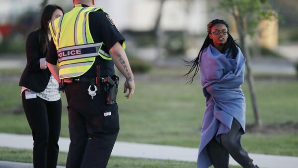An employee wrapped in a blanket talks to a police officer after she was evacuated at a FedEx distribution center where a package exploded, Tuesday, March 20, 2018, in Schertz, Texas. - Sputnik International