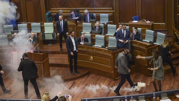 Kosovo policemen (R and L) prepare to remove a tear gas canister throwed by Kosovo's opposition lawmakers, in Pristina's parliament assembly room on March 21, 2018 before a vote on a key boarder deal with Montenegro - Sputnik International