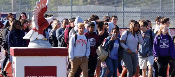 Students walk out of Marjory Stoneman Douglas High School as part of a National School Walkout to honor the 17 students and staff members killed at the school in Parkland, Florida, U.S., March 14, 2018. - Sputnik International