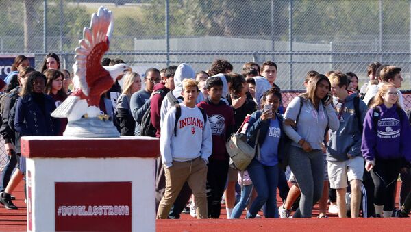 Students walk out of Marjory Stoneman Douglas High School as part of a National School Walkout to honor the 17 students and staff members killed at the school in Parkland, Florida, U.S., March 14, 2018. - Sputnik International