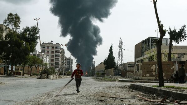 A child runs along a street in front of clouds of smoke billowing following a reported air strike on Douma, the main town of Syria's rebel enclave of Eastern Ghouta - Sputnik International