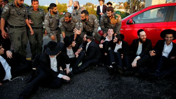 An Israeli ultra-Orthodox Jew block a main road in Israel before security forces evacuate them during a protest against the detention of a member of his community who refuses to serve in the Israeli army, in Bnei Brak, Israel - Sputnik International