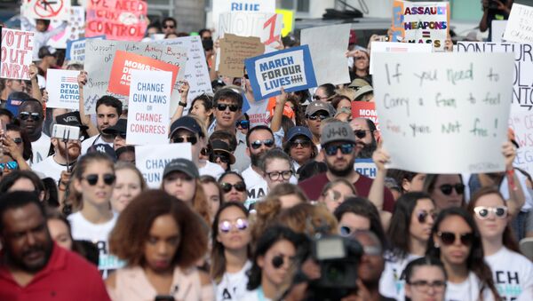 People and students hold signs while rallying in the street during the March for Our Lives demanding stricter gun control laws at the Miami Beach Senior High School, in Miami, Florida, U.S - Sputnik International
