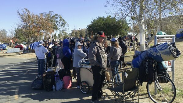 Homeless people line up in preparation to move from their homeless camp site along a riverbed in Anaheim, CA - Sputnik International