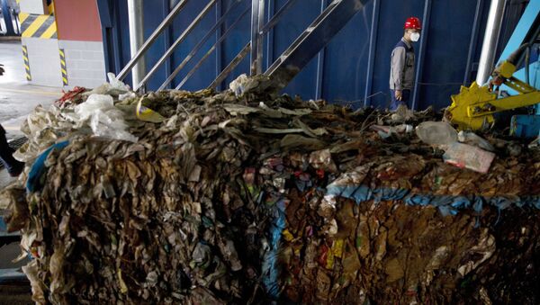 A worker walks past garbage being processed at the Majialou Garbage Transfer Station in Beijing, China, Thursday, March 30, 2017 - Sputnik International