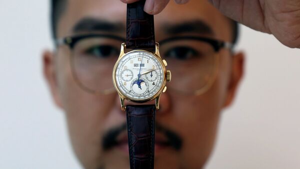 An exhibitor displays the Patek Philippe 18k gold perpetual chronograph wrist watch with moon phases belonging to the King Farouk, at the Christie's auction in Dubai, United Arab Emirates, March 19, 2018 - Sputnik International