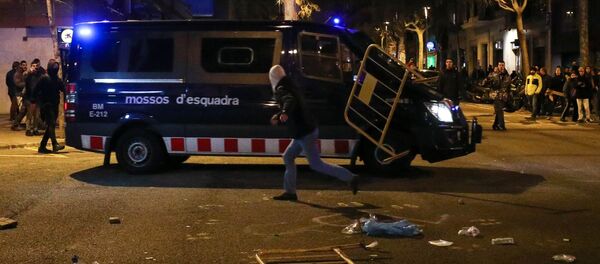 A protestor throws a barrier at a Catalan police van during skirmishes after former regional president Carles Puigdemont was detained in Germany, at a demonstration in Barcelona, Spain March 25, 2018. A protestor throws a barrier at a Catalan police van during skirmishes after former regional president Carles Puigdemont was detained in Germany, at a demonstration in Barcelona, Spain March 25, 2018. - Sputnik International