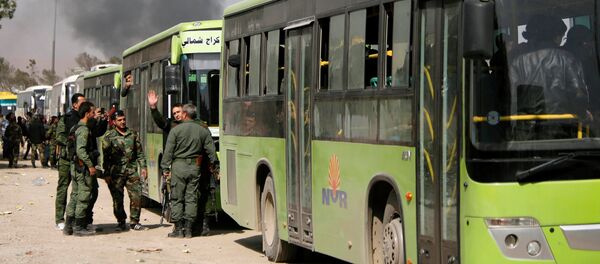Members of Syrian forces of President Bashar al Assad stand next to buses carrying rebels and their families before they are evacuated, at Harasta highway outside Jobar, in Damascus, Syria March 25, 2018 - Sputnik International