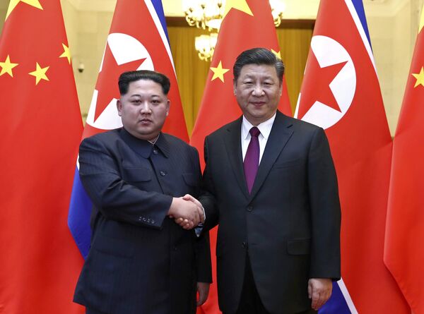 In this photo provided Wednesday, March 28, 2018, by China's Xinhua News Agency, North Korean leader Kim Jong Un, left, and Chinese President Xi Jinping shake hands in Beijing, China. In this photo provided Wednesday, March 28, 2018, by China's Xinhua News Agency, North Korean leader Kim Jong Un, left, and Chinese President Xi Jinping shake hands in Beijing, China. - Sputnik International