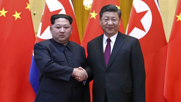 In this photo provided Wednesday, March 28, 2018, by China's Xinhua News Agency, North Korean leader Kim Jong Un, left, and Chinese President Xi Jinping shake hands in Beijing, China. - Sputnik International