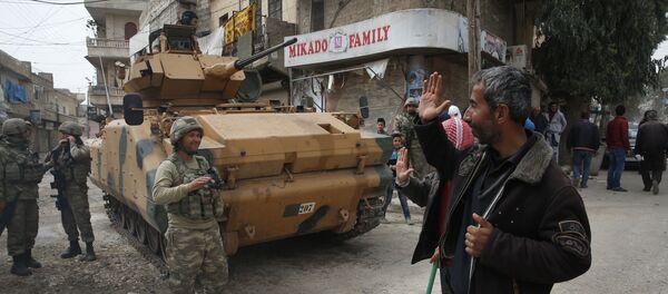 A Syrian man waves to Turkish soldiers securing the streets of the northwestern city of Afrin, Syria, during a Turkish government-organised media tour into northern Syria, Saturday, March 24, 2018 - Sputnik International