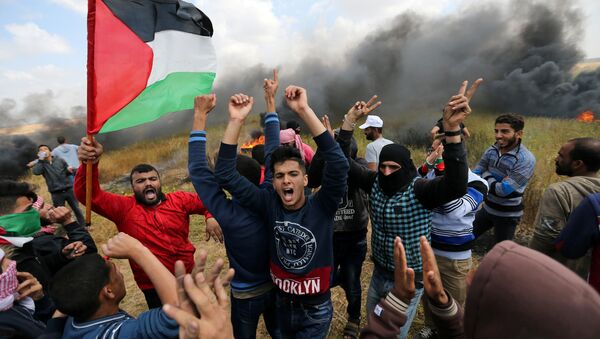 Palestinians shout during clashes with Israeli troops, during a tent city protest along the Israel border with Gaza, demanding the right to return to their homeland, the southern Gaza Strip - Sputnik International