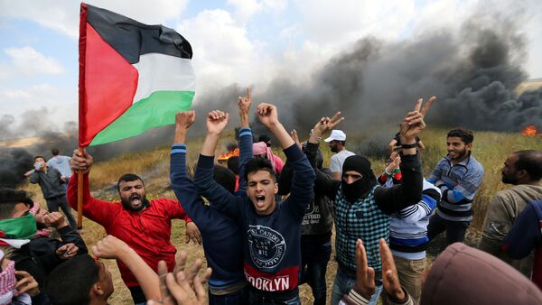 Palestinians shout during clashes with Israeli troops, during a tent city protest along the Israel border with Gaza, demanding the right to return to their homeland, the southern Gaza Strip March 30, 2018. - Sputnik International