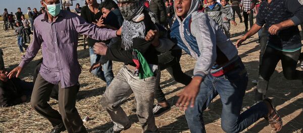 Protesters run during clashes with Israeli security forces following a demonstration near the border with Israel, east of Khan Yunis, in the southern Gaza Strip Protesters run during clashes with Israeli security forces following a demonstration near the border with Israel, east of Khan Yunis, in the southern Gaza Strip - Sputnik International