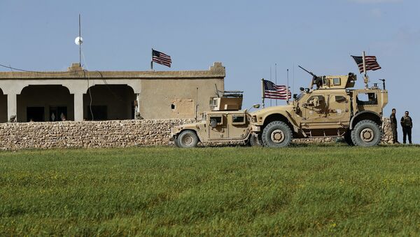 In this picture taken Thursday, March 29, 2018, U.S. soldiers, left, sit on a house that turned to an outpost on a road leading to the tense front line between U.S-backed Syrian Manbij Military Council fighters and Turkish-backed fighters, at Halawanji village, north of Manbij town, Syria - Sputnik International
