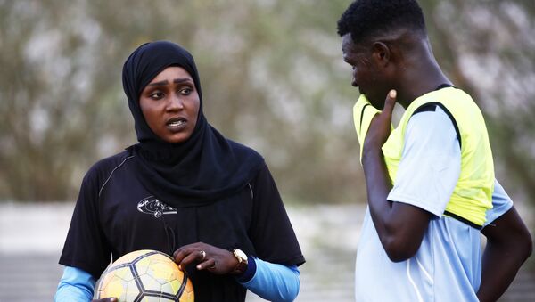 Salma al-Majidi, acknowledged by FIFA as the first Arab and Sudanese woman to coach a men's football team in the Arab world, coaches players of the Al-Ahly Al-Gadaref club during a training session in the town of Gedaref, east of Khartoum on February 17, 2018 - Sputnik International