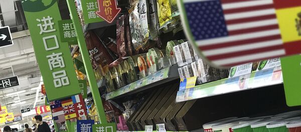 Women push a shopping cart near nuts and sweets imported from the United States and other countries displayed on a section selling imported foods at a supermarket in Beijing, Monday, April 2, 2018 - Sputnik International