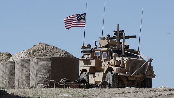 A U.S. soldier sits on an armored vehicle on a newly installed position, near the tense front line between the U.S-backed Syrian Manbij Military Council and the Turkish-backed fighters, in Manbij, north Syria, Wednesday, April 4, 2018 - Sputnik International