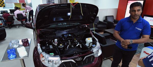 This photo taken on July 21, 2017 shows a sales executive talking about Mahindra's electric car e2o Plus on display at a showroom in New Delhi This photo taken on July 21, 2017 shows a sales executive talking about Mahindra's electric car e2o Plus on display at a showroom in New Delhi - Sputnik International