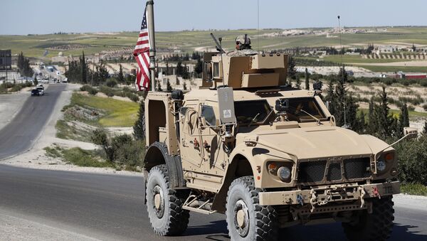 A U.S. soldier sits on an armored vehicle on a road leading to the tense front line with Turkish-backed fighters, in Manbij, north Syria, Wednesday, April 4, 2018 - Sputnik International