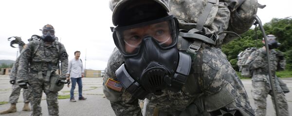 A soldiers of the U.S. Army 23rd chemical battalion wearing a gas mask rests after a competition at Camp Stanley in Uijeongbu, South Korea, Wednesday, July 8, 2015 - Sputnik International