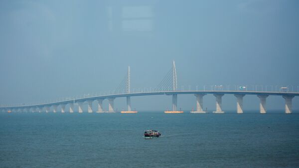 A boat sails in front of the Hong Kong-Zhuhai-Macau Bridge, to be opened in Zhuhai, China March 28, 2018 - Sputnik International