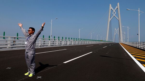 A man poses on a section of the Hong Kong-Zhuhai-Macau Bridge, to be opened in Zhuhai, China March 28, 2018 - Sputnik International