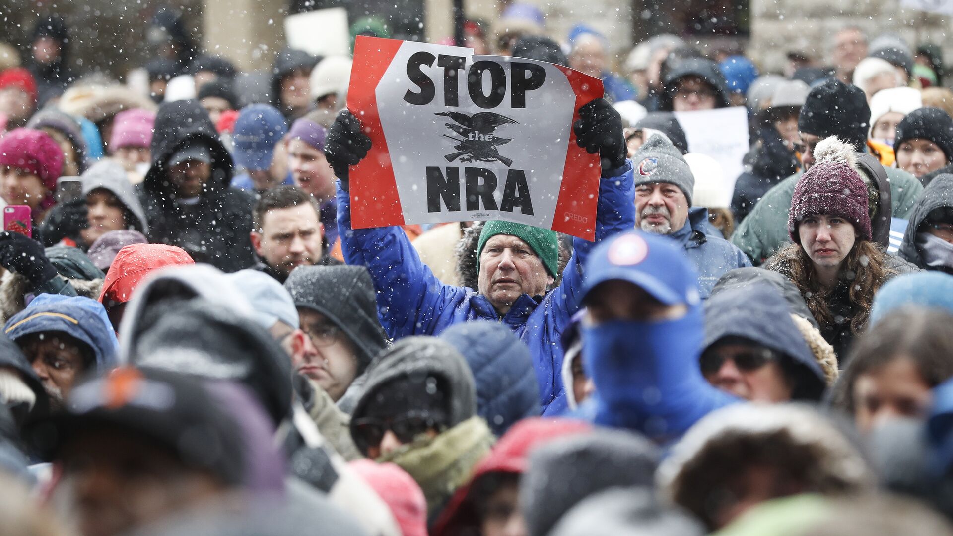 A demonstrator holds a STOP the NRA sign outside city hall during the March for Our Lives protest for gun legislation and school safety, Saturday, March 24, 2018 - Sputnik International, 1920, 14.02.2022