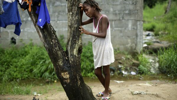 A child cries as community activists approach her outside her home in Liberia, a day after her mother was taken away by an ambulance to an Ebola ward, - Sputnik International