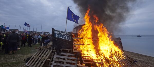 The remains of a small boat flying European flags is burnt on a bonfire during a demonstration in Whitstable, southeast England on April 8, 2018 against the Brexit transition deal that would see Britain continue to adhere to the Common Fisheries Policy after formally leaving the EU - Sputnik International