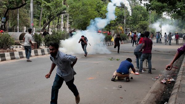 Bangladeshi students run for cover after policemen fire tear gas as they protest for removing or reforming a quota system in government jobs in Dhaka, Bangladesh, Monday, April 9, 2018 - Sputnik International