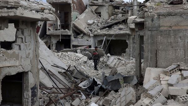 A man stands on rubble of damaged buildings in the besieged town of Douma, Eastern Ghouta, in Damascus, Syria March 30, 2018 - Sputnik International