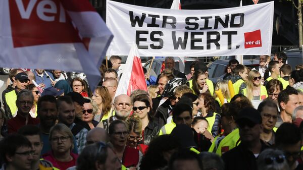 Members of the ver.di union with a banner reading: ' We are worth it.' attend a rally as part of a public sector pay strike in Berlin, Germany - Sputnik International