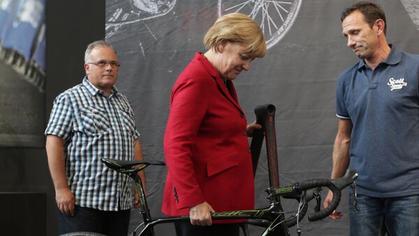 German chancellor Angela Merkel lifts a bicycle at the opening day of the Eurobike 2013, in Friedrichshafen, southern Germany. (File) - Sputnik International