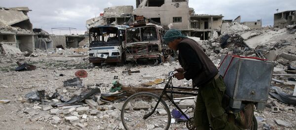 A man walks with his bicycle at a damaged site in the besieged town of Douma, Eastern Ghouta, in Damascus, Syria - Sputnik International