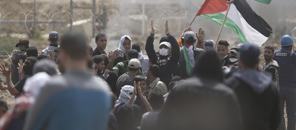 Palestinian protesters chant slogans as they gather during a protest at the Gaza Strip's border with Israel, Friday, 13 April 2018. - Sputnik International