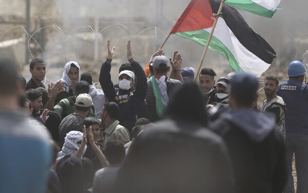 Palestinian protesters chant slogans as they gather during a protest at the Gaza Strip's border with Israel, Friday, April 13, 2018 - Sputnik International