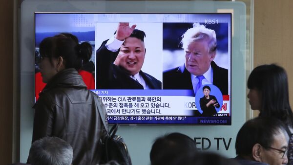 People pass by a TV screen showing file footages of U.S. President Donald Trump, right, and North Korean leader Kim Jong Un during a news program at the Seoul Railway Station in Seoul, South Korea, Monday, April 9, 2018 - Sputnik International