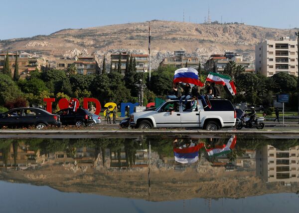 Syrian government supporters chant slogans against U.S. President Trump during demonstrations following a wave of U.S., British and French military strikes to punish President Bashar Assad for suspected chemical attack against civilians, in Damascus, Syria, Saturday, April 14, 2018 Syrian government supporters chant slogans against U.S. President Trump during demonstrations following a wave of U.S., British and French military strikes to punish President Bashar Assad for suspected chemical attack against civilians, in Damascus, Syria, Saturday, April 14, 2018 - Sputnik International