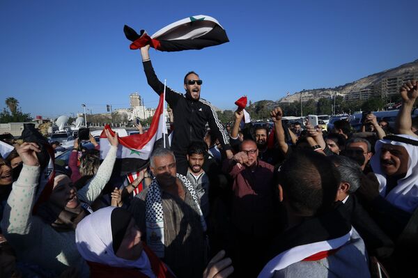 Syrian government supporters chant slogans against U.S. President Trump during demonstrations following a wave of U.S., British and French military strikes to punish President Bashar Assad for suspected chemical attack against civilians, in Damascus, Syria, Saturday, April 14, 2018 Syrian government supporters chant slogans against U.S. President Trump during demonstrations following a wave of U.S., British and French military strikes to punish President Bashar Assad for suspected chemical attack against civilians, in Damascus, Syria, Saturday, April 14, 2018 - Sputnik International